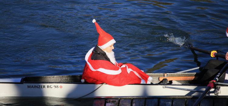Eine als Nikolaus hergerichtete Steuerfrau im Ruderboot mit dem Namen „Nikolaus“.