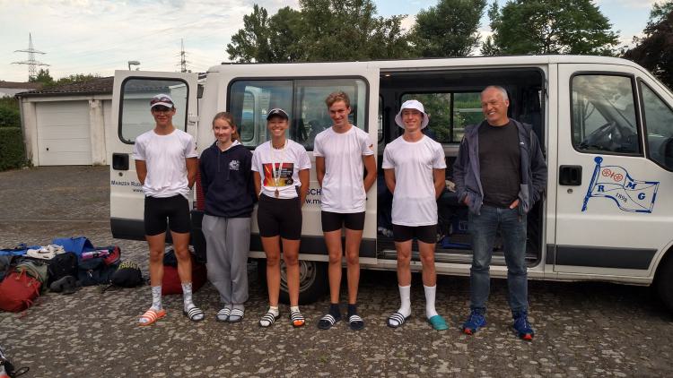 Die MRG-Athlet*innen bei der deutschen Junioren-Meisterschaft in Köln vor der Minna auf dem Bootsplatz in Mainz: (v.l.n.r.: Maxim Gorlier, Charlotte Münzing, Josefine Günther (Bronze), Mathis Seckler, Len Gruber, Trainer Peter Plötz).